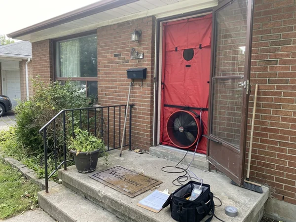 Blower door fan in the front door of an East York bungalow during an energy audit