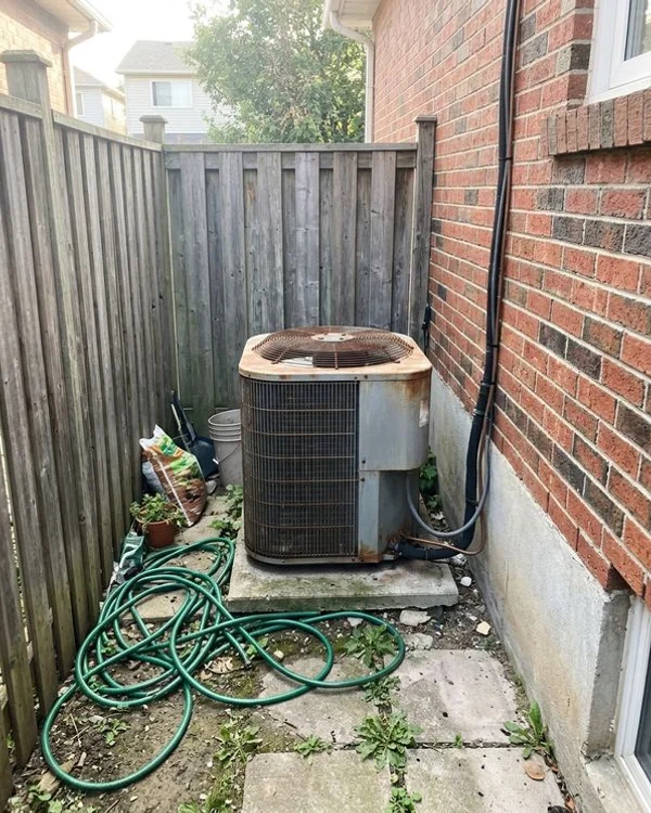 Old top-discharge condenser crammed into a narrow side yard