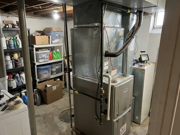 Cased coil on top of a two-stage gas furnace in a dual-fuel setup
