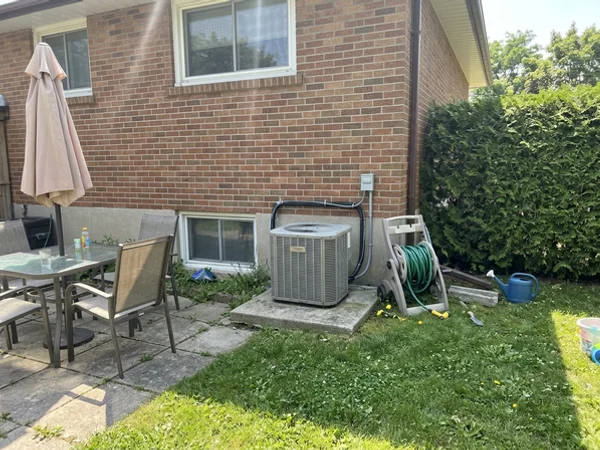 Central ducted air-source heat pump behind an Etobicoke side-split