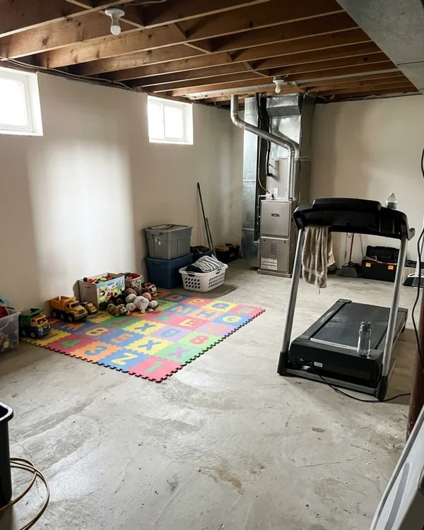 Same basement with a Mitsubishi air handler and open floor after the oil removal