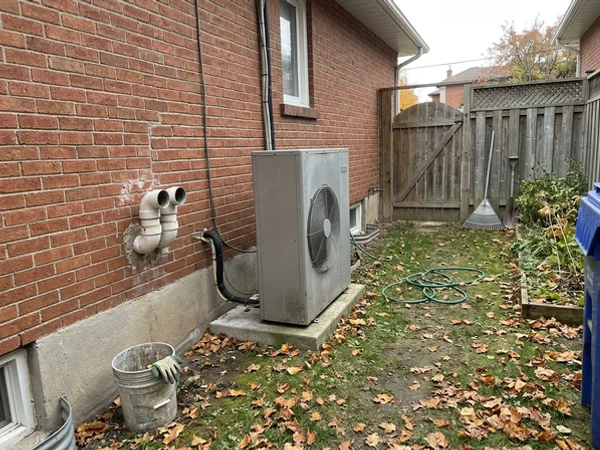 Daikin Fit on a raised pad beside a Leaside home in a dual-fuel setup