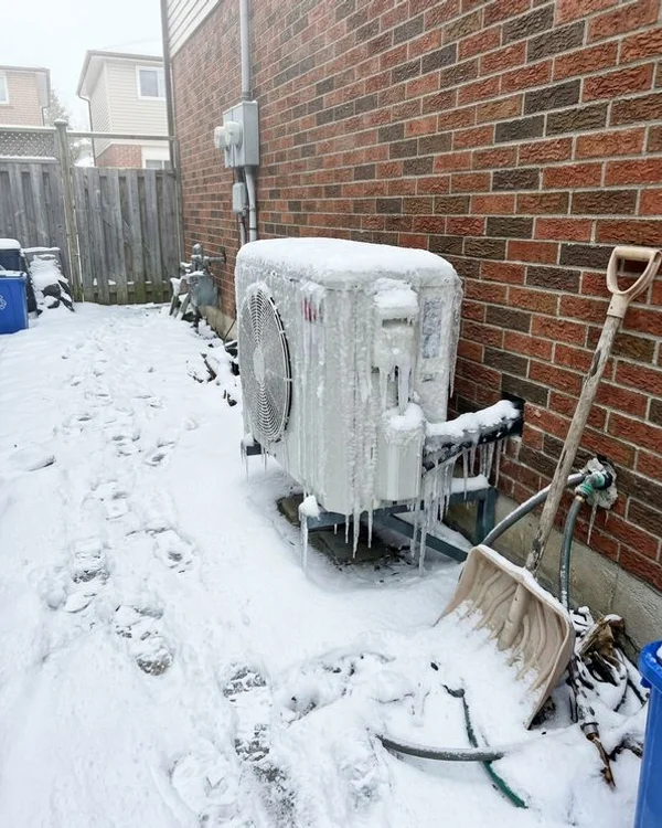Outdoor unit covered in thick ice with the fan blocked