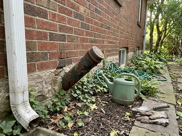 Oil fill pipe removed from an exterior brick wall